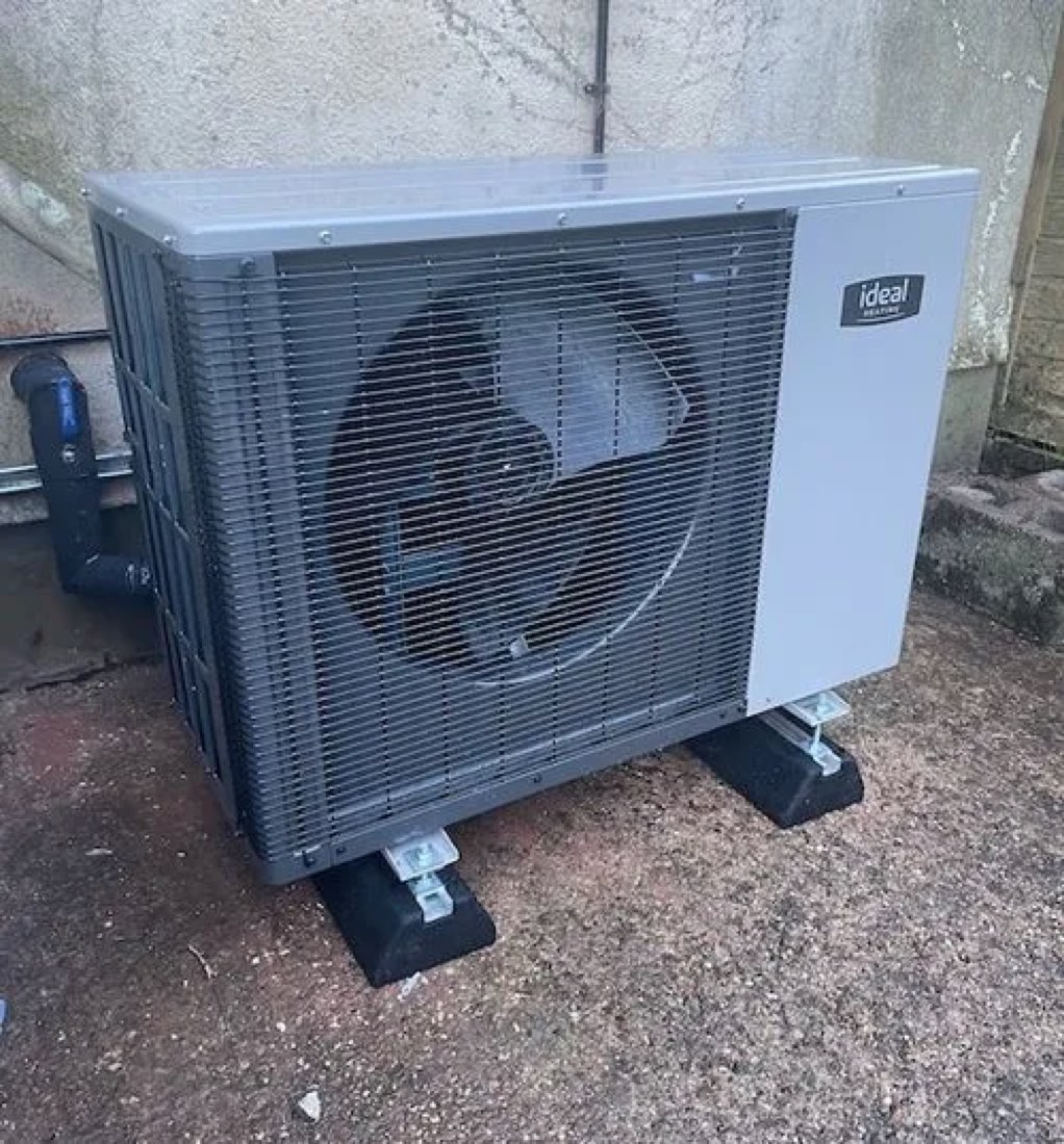 A 5 kW heat pump on anti-vibration feet beside a wall