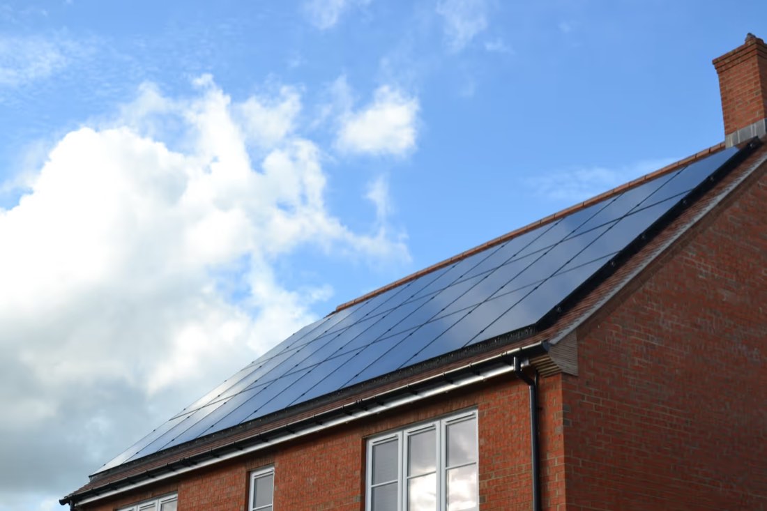 Black solar panels on a red-brick house